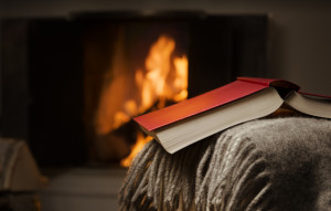 Peaceful and warm image of a open book by fireplace.